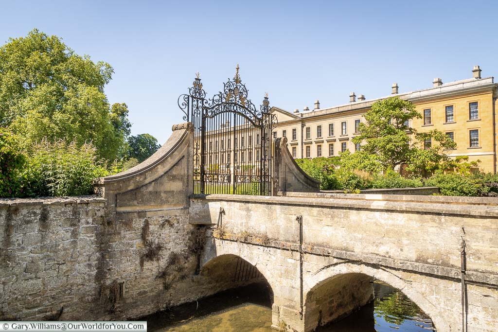 A small stone bridge over the River Cherwell in front of the New Building of Magdalen College, Oxford
