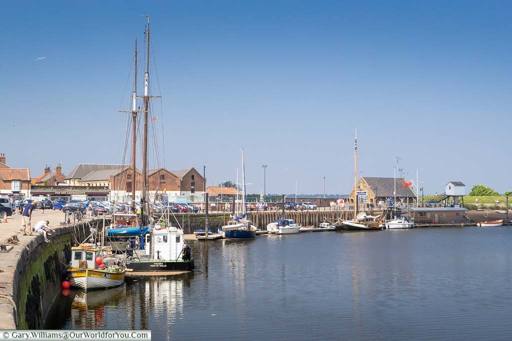 Boats moored up at the curved quayside at Wells-next-the-Sea on the North Norfolk coastline
