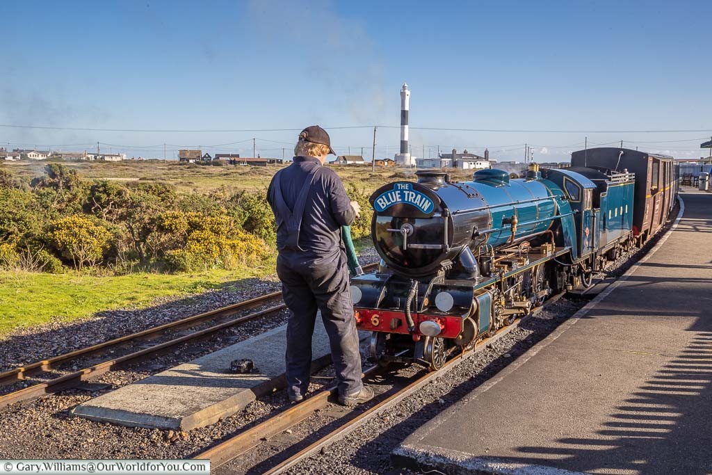 The Romney, Hythe & Dymchurch Railway miniature steam locomotive Samson being given a polish by the driver as the train is waiting at the Dungeness train station.