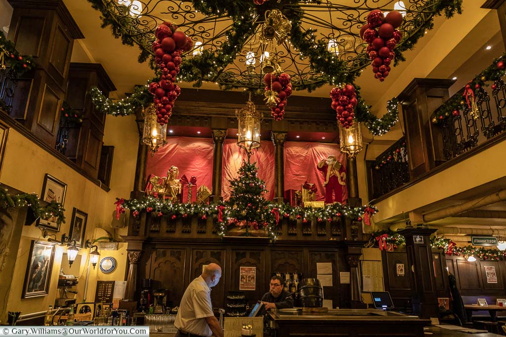 Inside the Christmas decorated Bierhaus en d'r Salzgass, a traditional Kolsch pub with beer barrel on the bar.