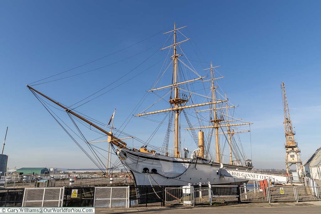 HMS Gannet, at home in its dock at the Historic Chatham Dockyard with its rigging contrasted against the blue sky.
