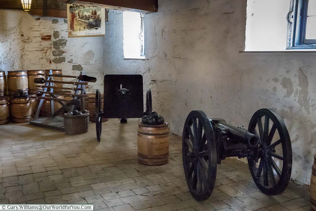 A couple of iron cannons, some iron shot, and barrels in an exhibition room in Upnor Castle