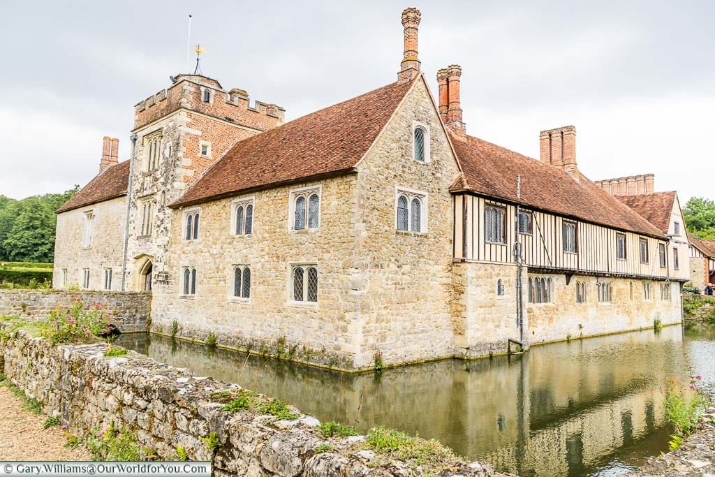 A view from the corner of moat of the medieval stone manor house of Ightham Mote