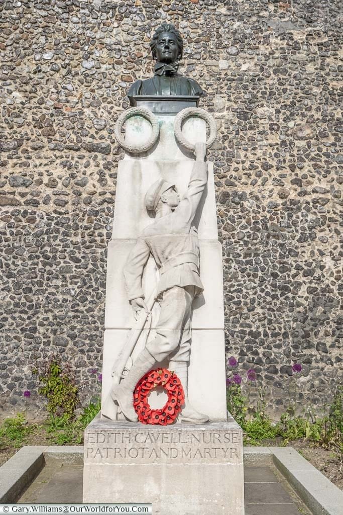 A stone pillar, topped with a bust of Edith Cavell, stands as a memorial to her bravery, in front of the walls of Norwich Cathedral in Norfolk