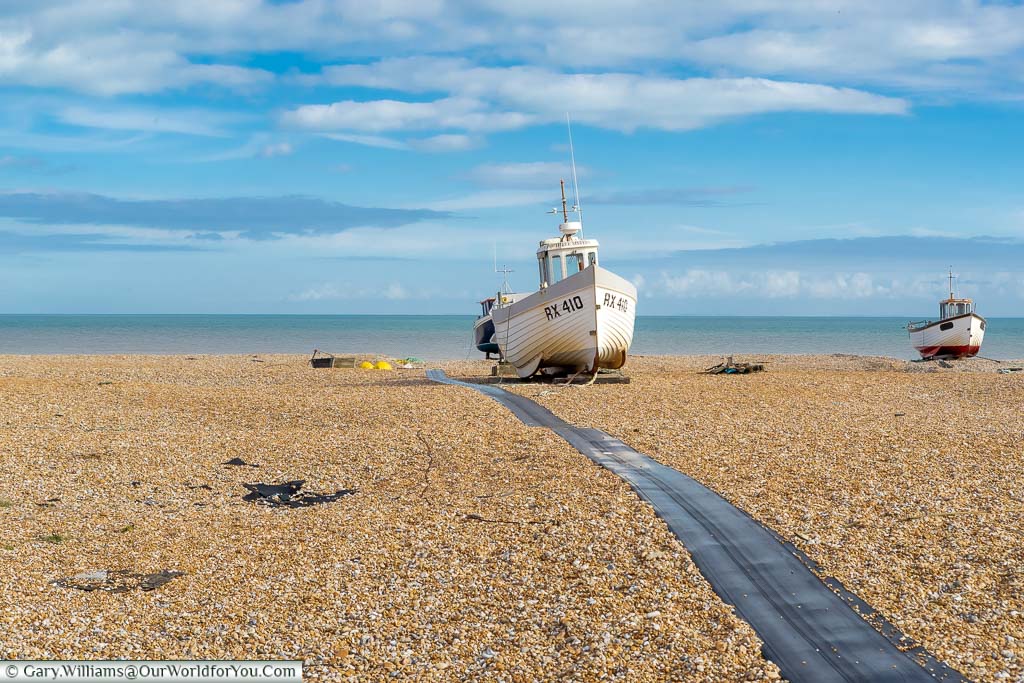 A couple of small fishing boats on the cobbled beach of Dungeness