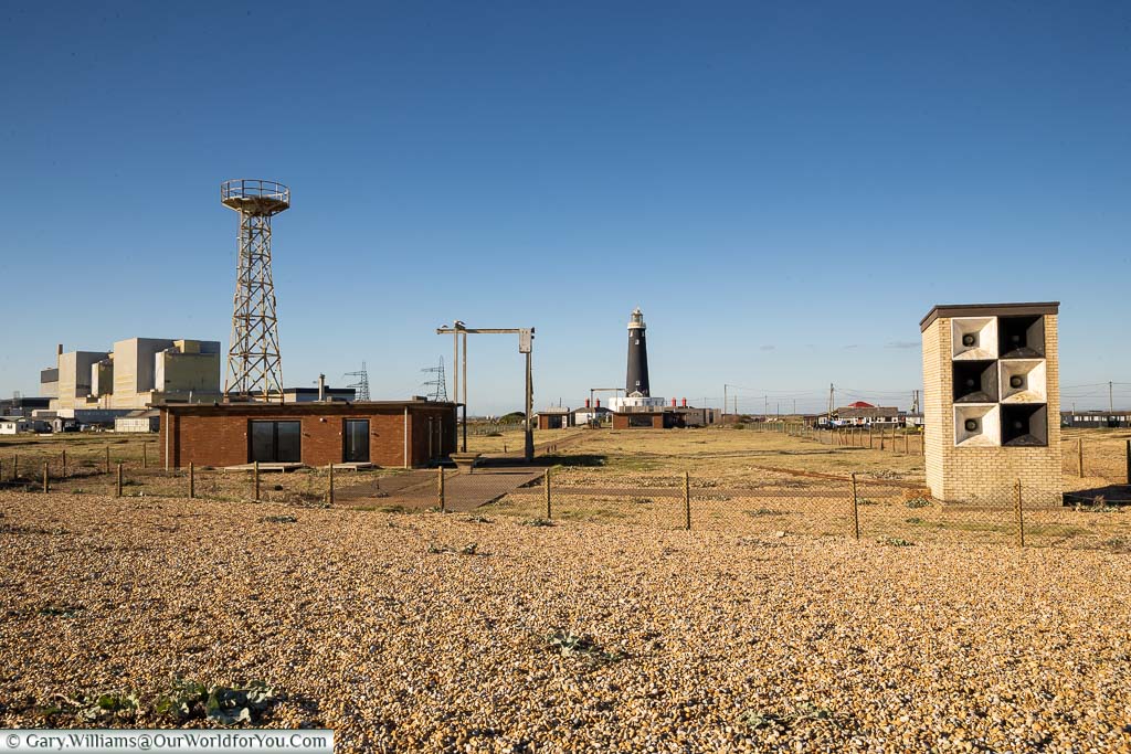 The utilitarian view of Dungeness, with the old lighthouse and power station in the background, and a coastal fog horn array in the foreground