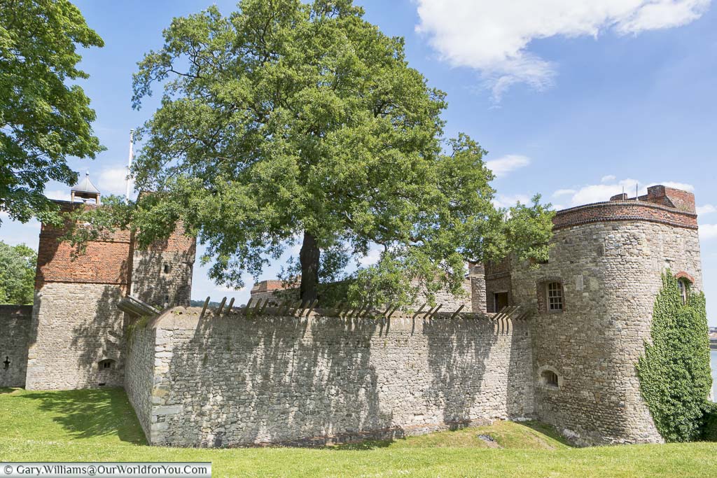 The stone wall that surrounds Upnor Castle from the land side, with the tower above the entrance, and another on the riverside edge.