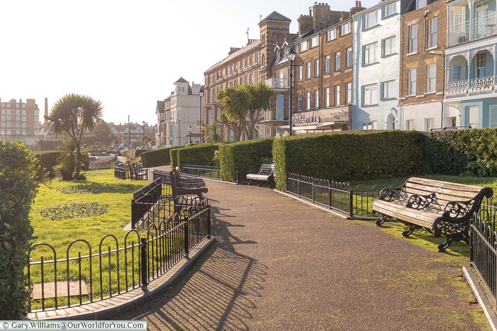 A pathway leading through Victoria parade and gardens lined on one side by the Georgian terraced buildings the overlook the bay at Broadstairs.
