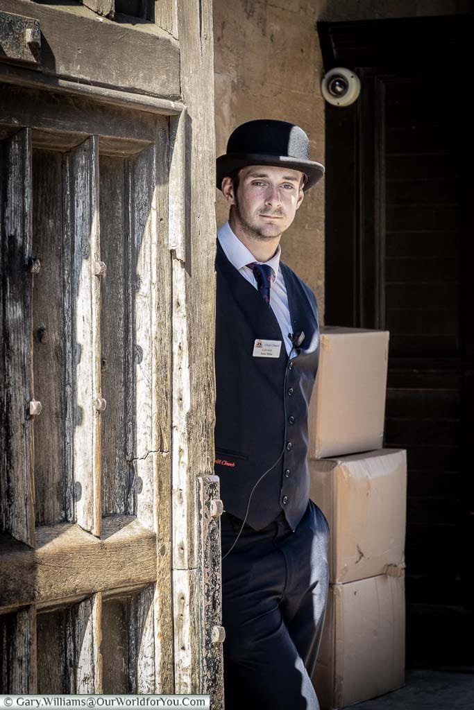 A Bowler hatted porter at the gates to Christ Church College, Oxford