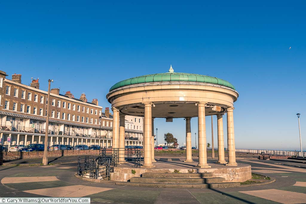 Ramsgate's bandstand in Wellington Crescent with the green glazed tiled roof above a cream tiled bandstand.