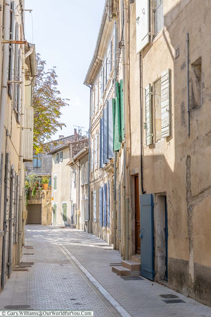 A quiet backstreet of 3 storeys shuttered buildings in Saint Remy de Provence