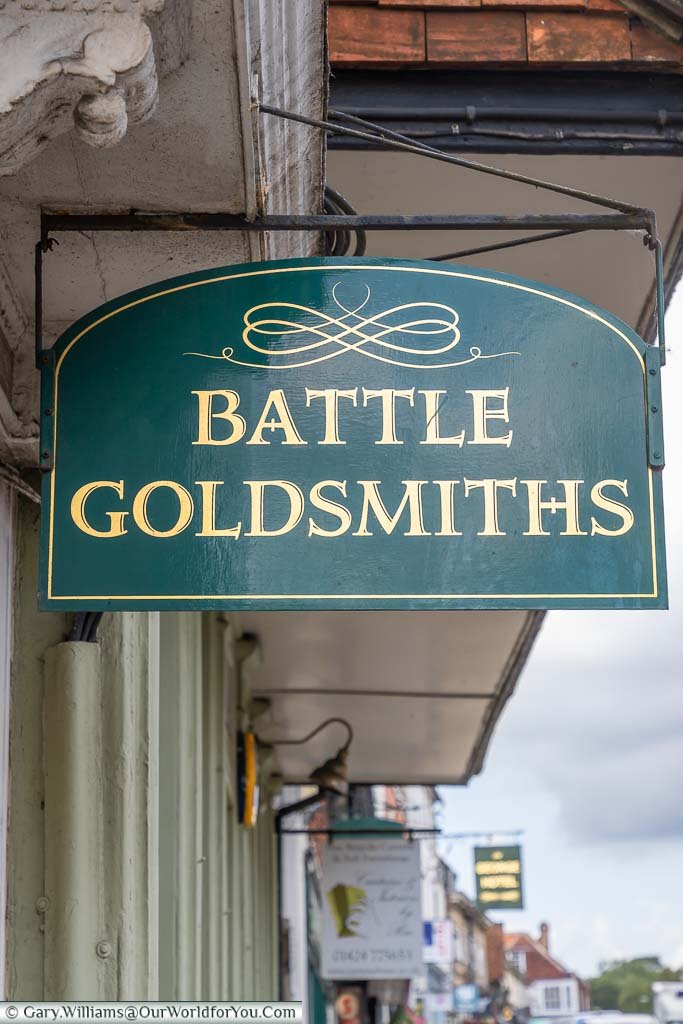 An ornate handpainted sign of gold on green for Battle Goldsmiths on Battle High Street, East Sussex