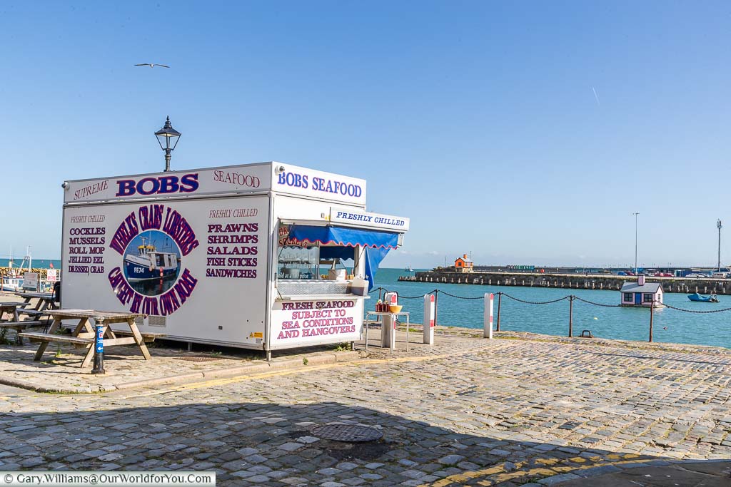 Bob’s Seafood stall overlooking the harbour under a deep blue sky.