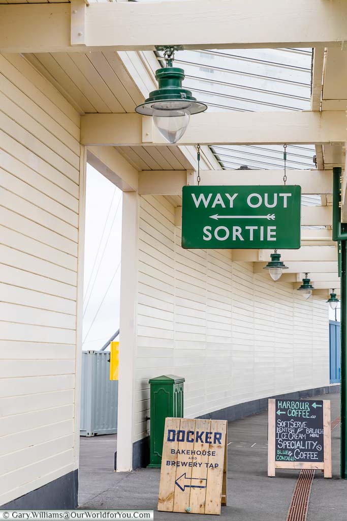 A look down the platform to the exit sign on the Folkestone Harbour station in both English & French.