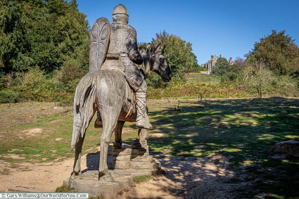A wooden statue of a Norman soldier on horseback looking across the battlefield towards the Abbot's house.