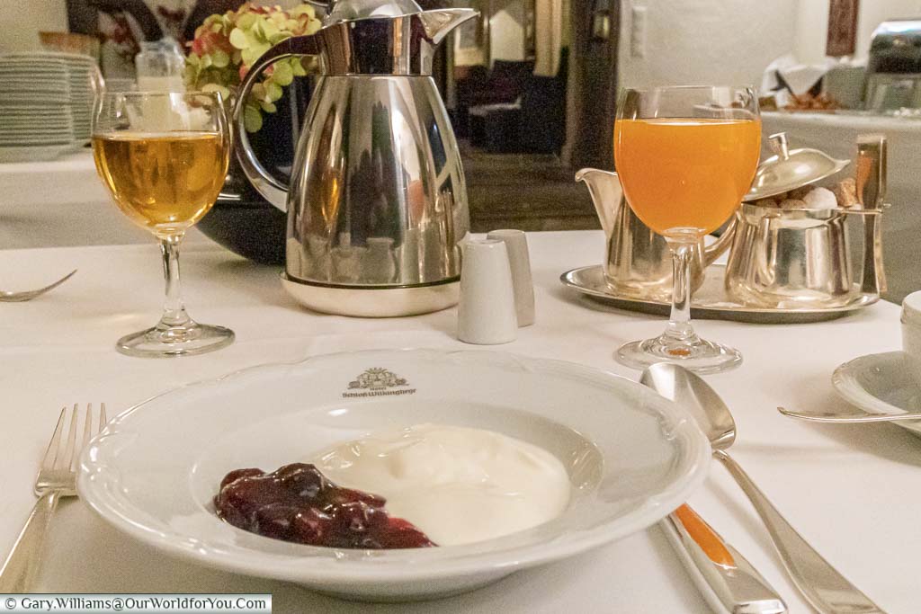 A breakfast course at Schloss Wilkinghege of natural yoghurt and cherry compote, with a glass of orange juice. The breakfast selection is extensive and of the finest quality.