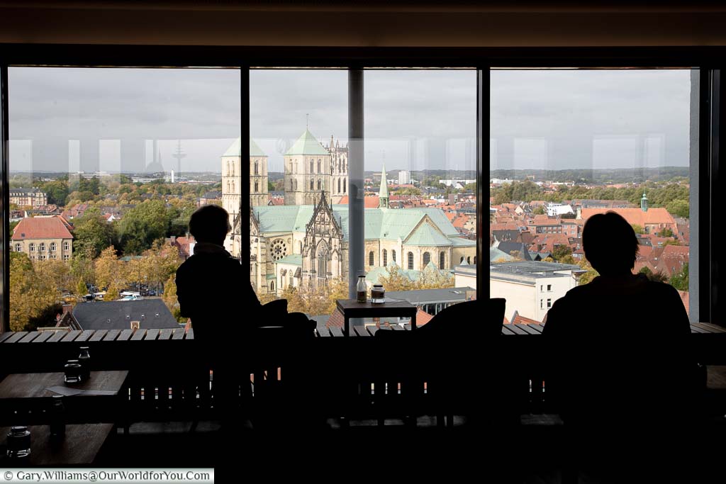 The silhouette of two women in Café 1648 enjoying the 12th-floor panoramic view of St.-Paulus-Dom.
