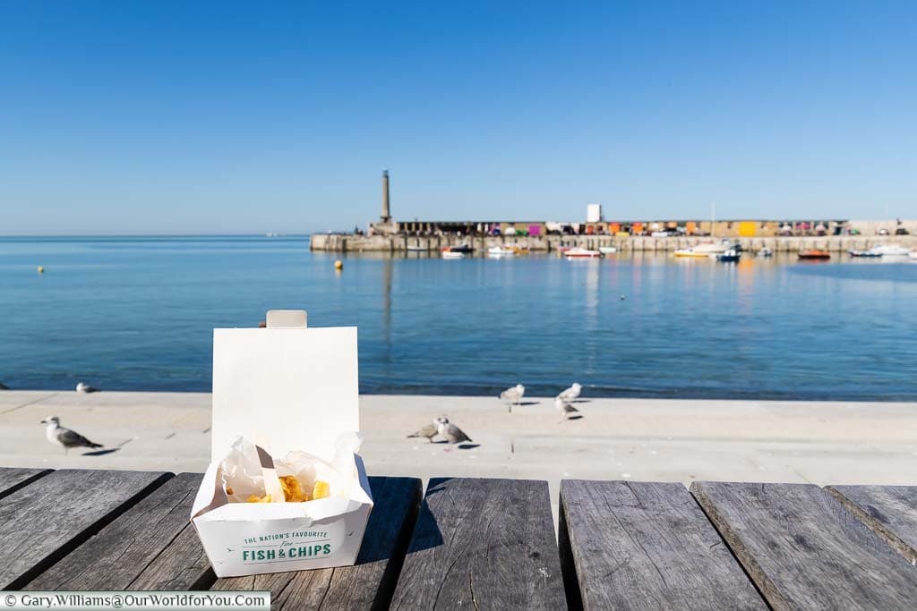 A small portion of Fish 'n' Chips in a cardboard container by the sea at Margate, Kent