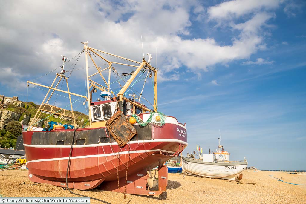 A couple of small fishing boats on the single beach at Hastings, on the East Sussex coast of England.