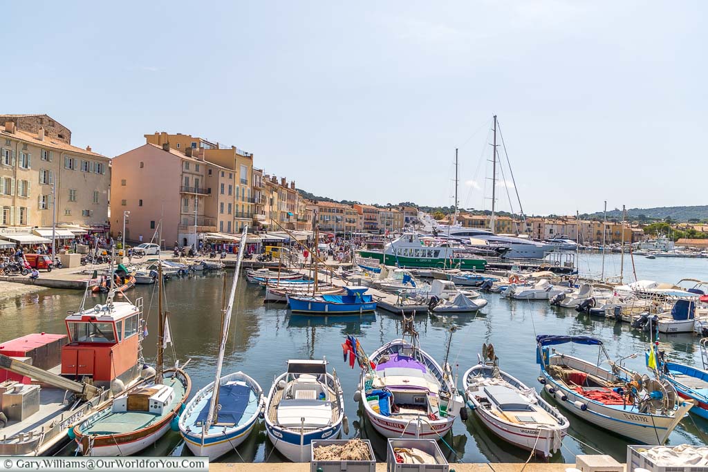 Looking down on the old harbour of Saint Tropez from the raised city walls. The old port is filled with traditional, small, fishing boats, but in the background, you can also make out the super yachts this town is famous for.