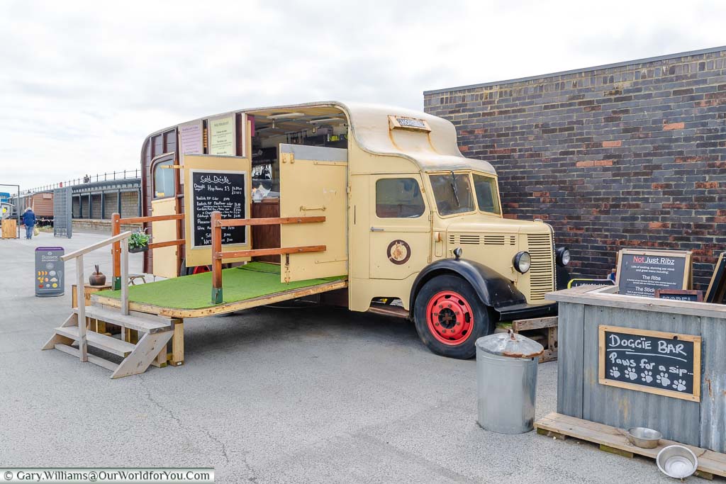 A cream coloured 1930's Bedford horsebox truck converted to a takeout bar & restaurant.