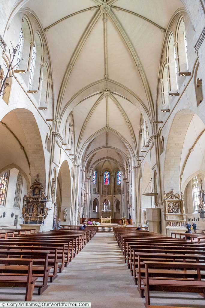 The view along the nave of St Paulus Dom towards the altar. The Cathedral has a high vaulted ceiling of white stone.