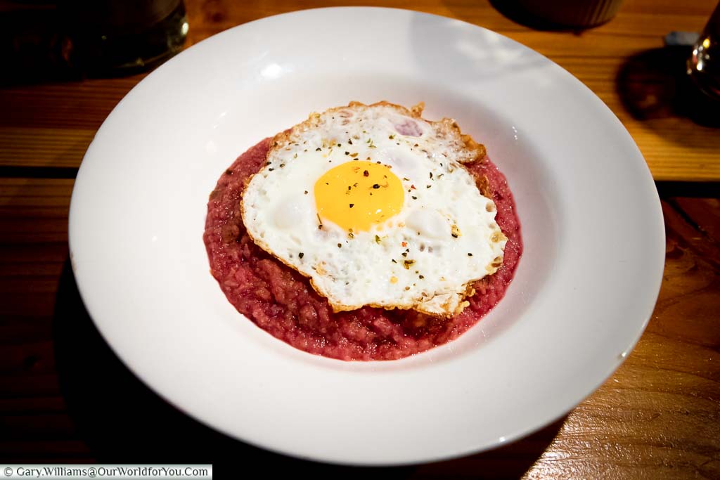 A bowl of Labskaus. A traditional corn beef and beetroot hash with a fried egg placed on top. This is a regional speciality of Hamburg.