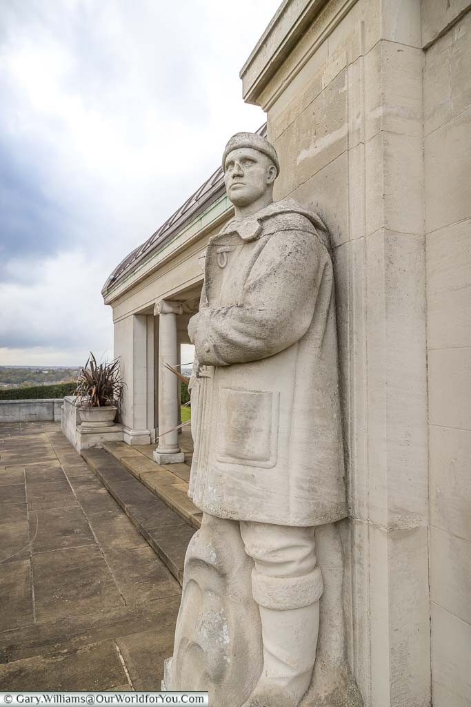 A stone sailor, wrapped in a heavy duffle coat, places as a lookout over Chatham from the Chatham Naval Memorial,