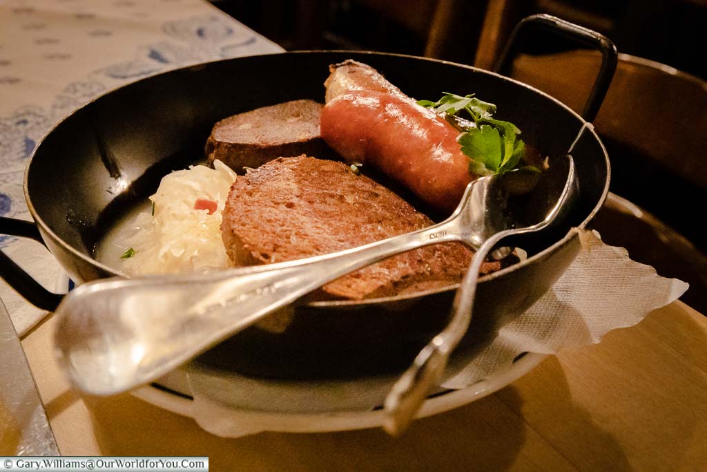A selection of local sausages, traditional food for the region, all served with sauerkraut in a cast-iron bowl at Altes Gasthaus Leve.