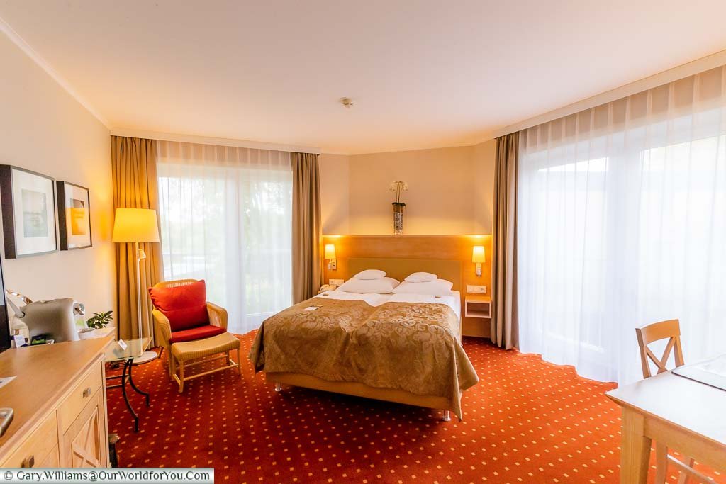 Our spacious, brightly lit, bedroom a the Best Western Premier Alsterkrug Hotel featuring a large double bed with two individual quilts, and separate working area.