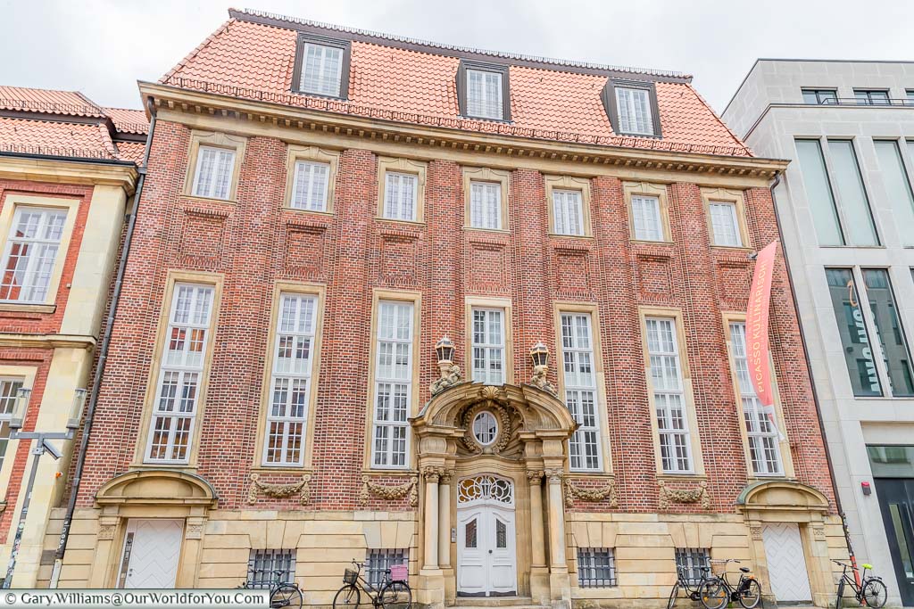 The red brick building houses the Pablo Picasso museum extension. The facade is grand in stature, but relatively plain except for the baroque style front door.