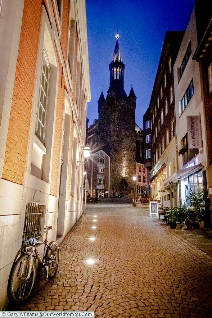 The cobbled lane of Rommelsgasse that runs between the Rathaus and the Hof at dusk. A the end of the path you can see one of the towers of the town hall.