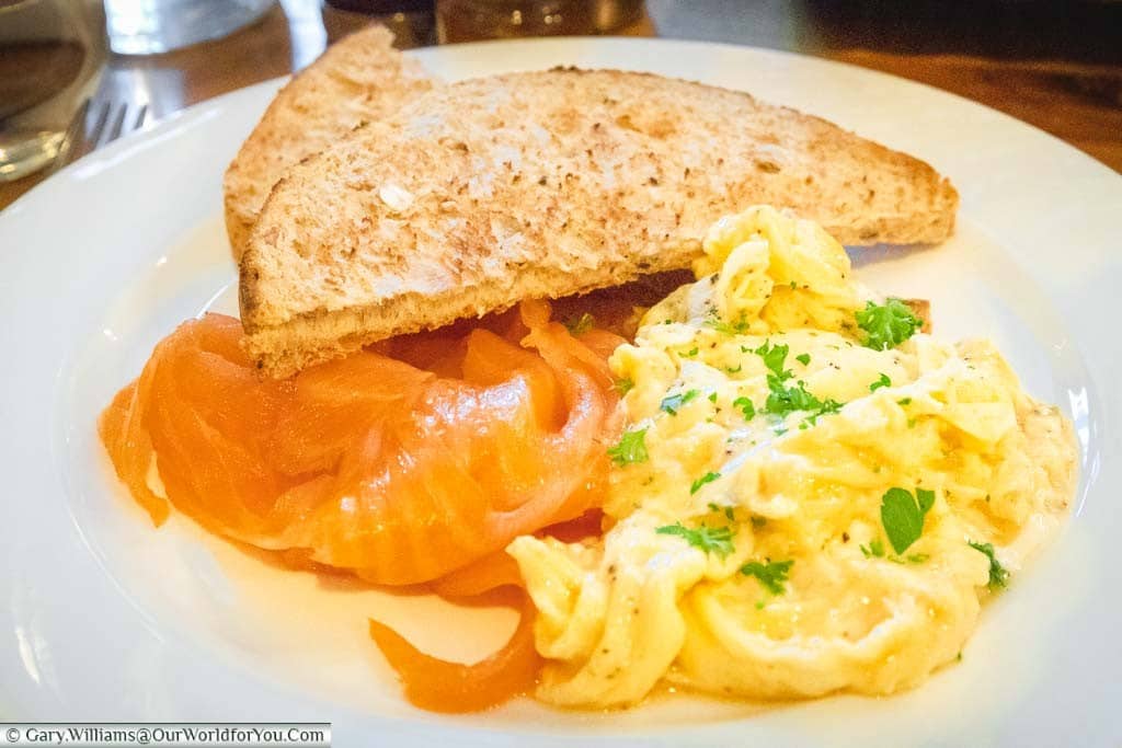 A generous portion of smoked salmon and scrambled egg with wholegrain toast