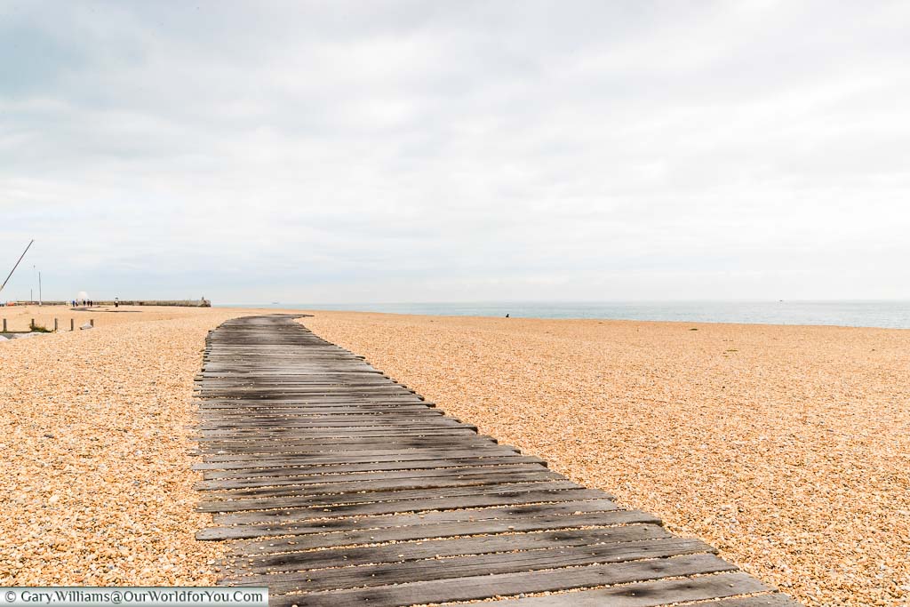 A path about 2 meters wide, constructed of wooden boards, across Folkestone's shingle beach.