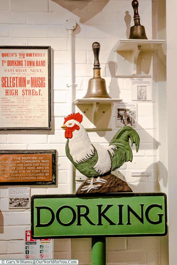 Exhibits in the Dorking Museum & Heritage Centre, featuring the Dorking Cockerel on a street signpost