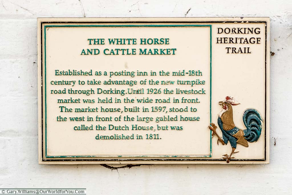 A cast-iron plaque on the White Horse Hotel for the Dorking Heritage Trail recognising its place as a posting Inn and the site of the Cattle Market