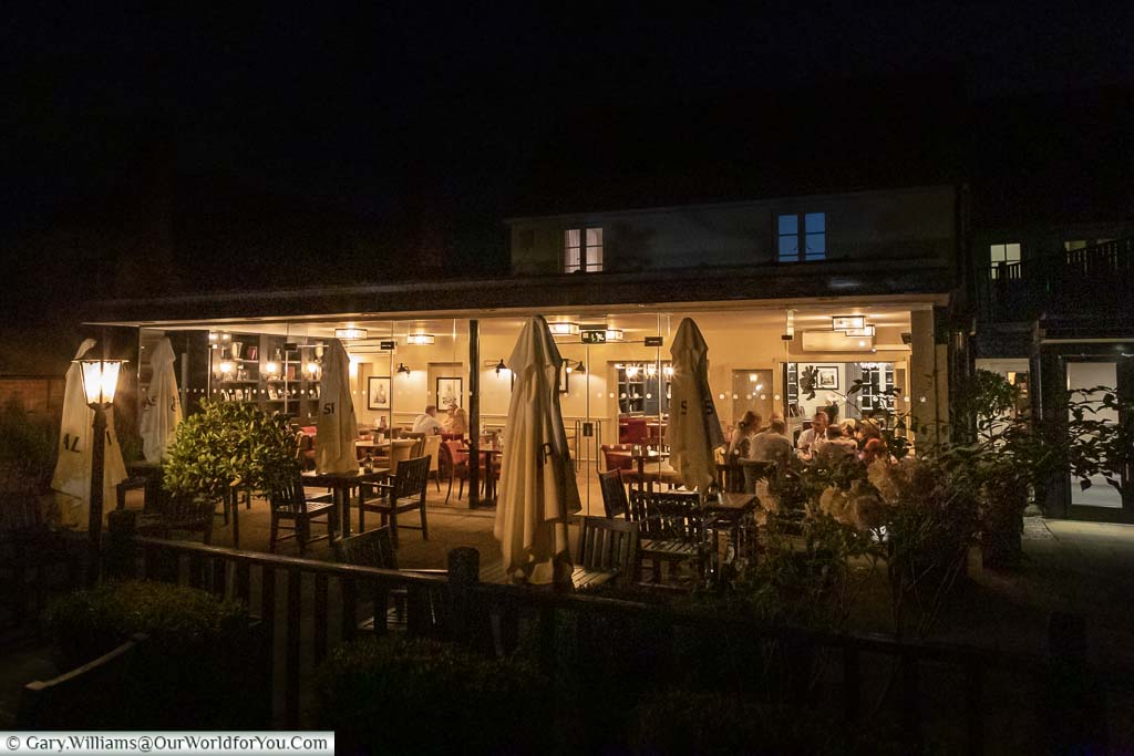 The Garden Room of the Talbot Inn at night. A glass-fronted extension to the restaurant where diners can enjoy their food while overlooking the Inn's gardens.