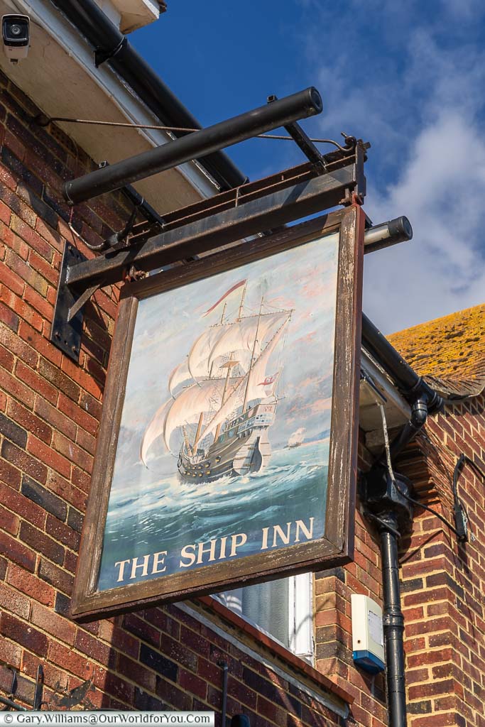 The Ship Inn pub sign with a painted 17th-century warship on the ocean wave.