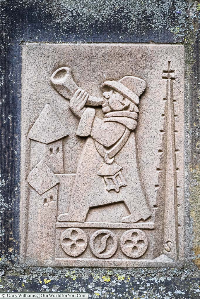 The stone plaque at the base of the bell tower of St. Lamberti church depicting the tower warden.