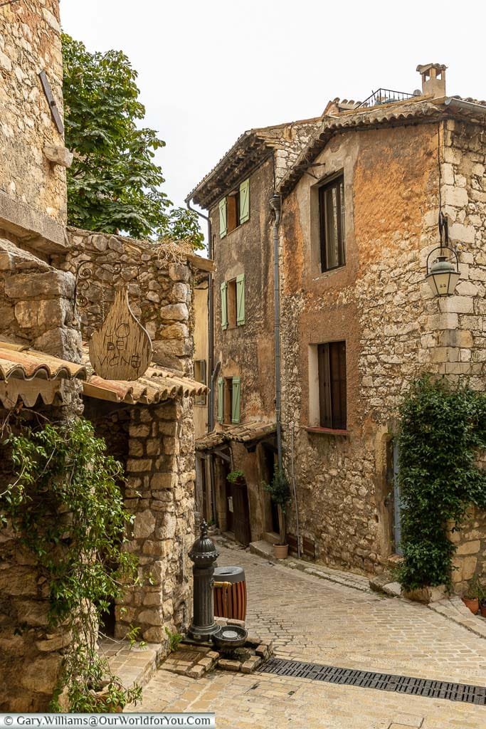 A narrow cobbled lane between rough stone provencal buildings in Tourrettes sur Loup