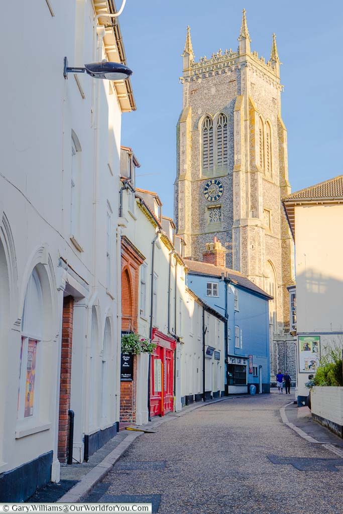 The tower of St Peter and St Paul's church catching the sunlight as you stroll along Cromer's High Street.