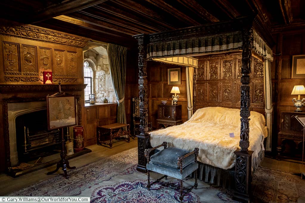 The dark, oak-panelled, King Henry VIII's bed chamber complete with a four-poster bed at Hever Castle in Kent