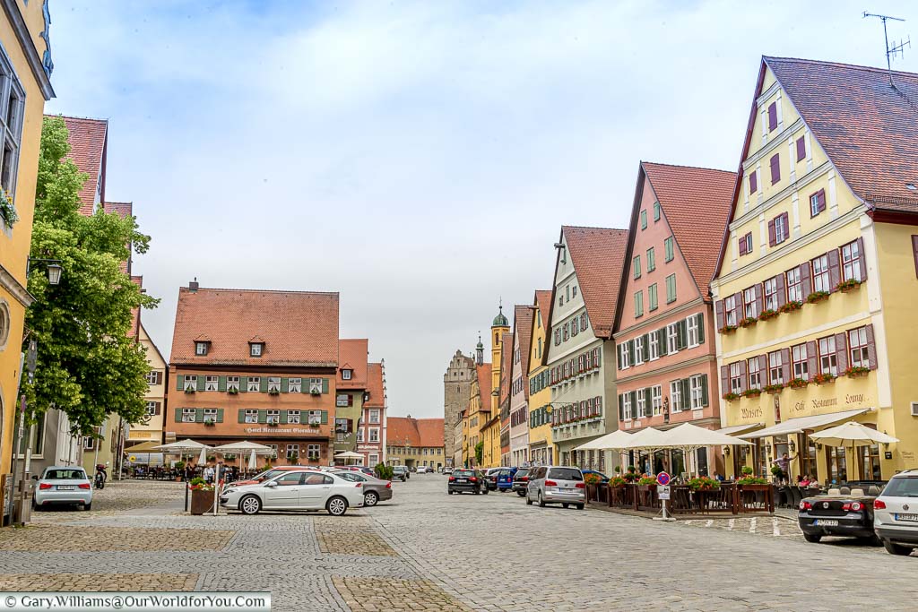 The main route through Dinkelsbühl with the typical three-storey buildings, with steep roofs and shops and restaurants occupying the lower floors. Each building is a different, muted, colour