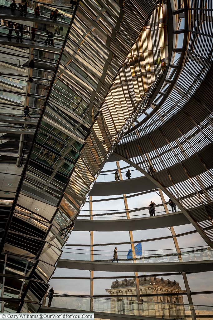 Inside the dome of the Reichstag. A portrait view of the spiral staircase and the central inverted reflector the transfers daylight down to the debating chamber below.
