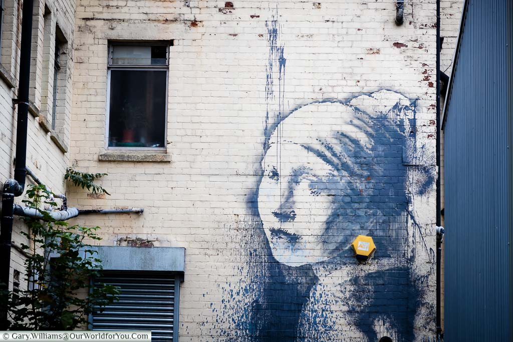 The Banksy street art graffiti piece 'The Girl with the Pierced Eardrum' painted on a wall in the back of the Bristol Marina