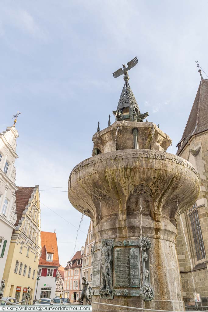 An ornate stone fountain topped with an iron eagle in the centre of Nördlingen