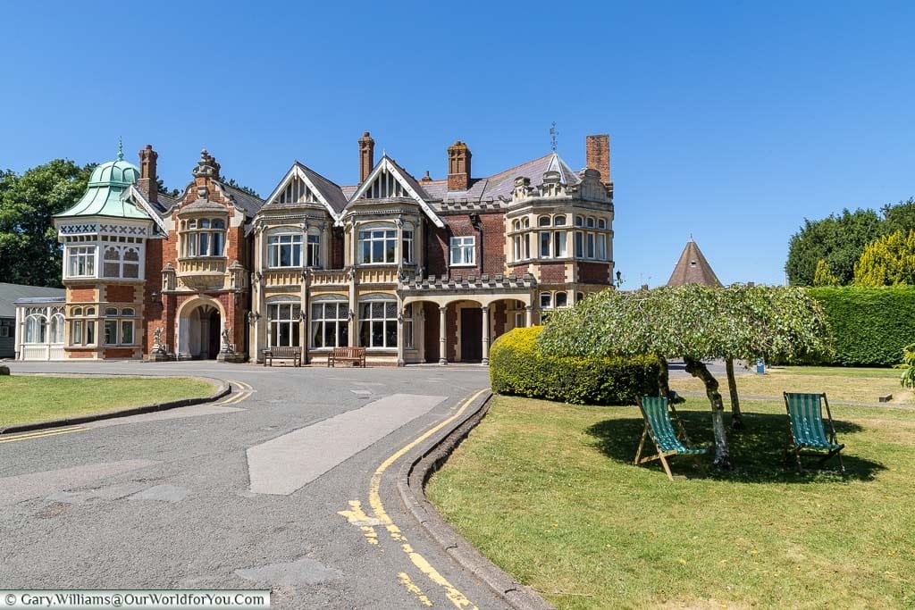 The Mansion at Bletchley Park, with deck chairs placed in the shade in the foreground.