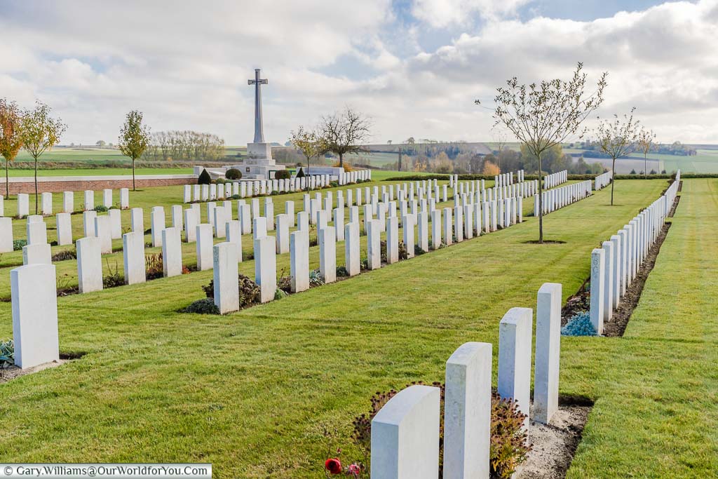 The looking over the back of the headstones to the Cross of Sacrifice in the Warloy-Baillon Communal Cemetery, France