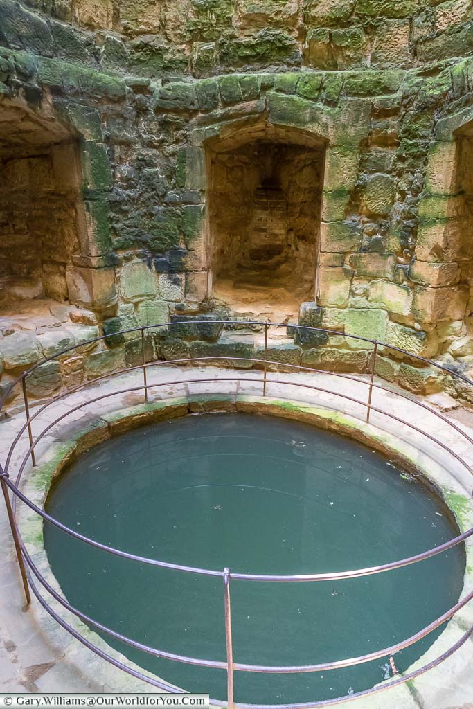 A large well filled with water in the southwest corner tower of Bodiam Castle