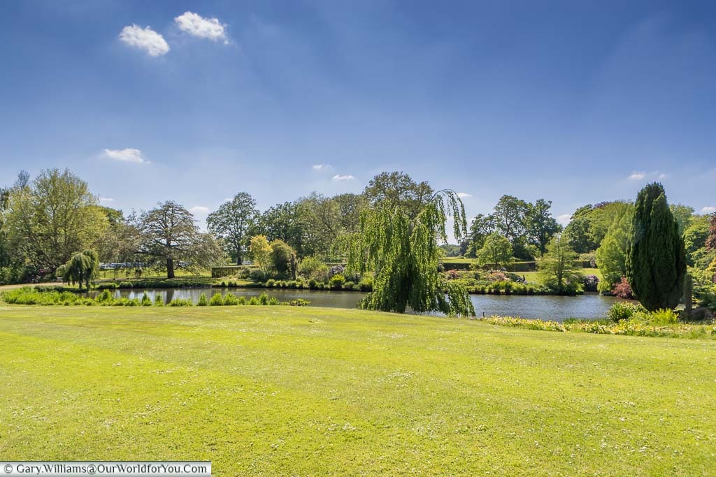The duck pond at Sandringham House from the beautifully manicured lawns, under a deep blue sky.